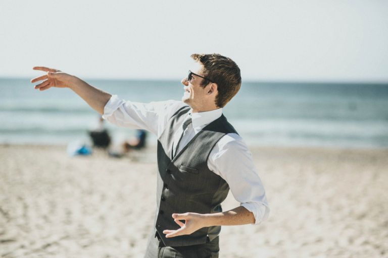 Throwing frisbee on the beach wearing a suit