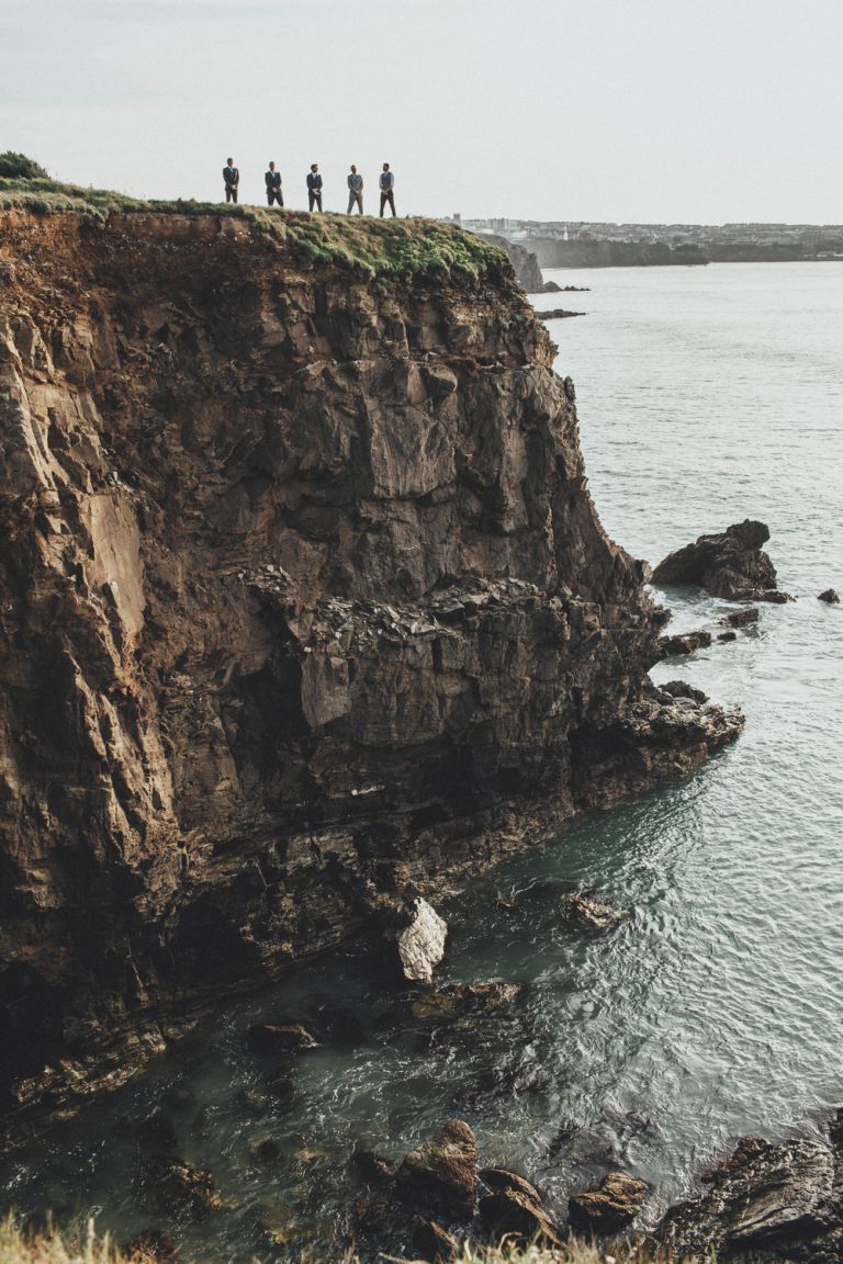 Groomsmen standing on cliff