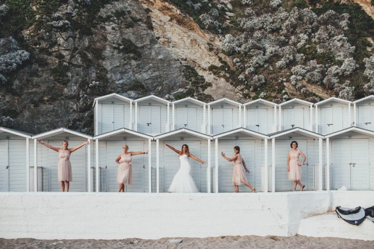 Bridesmaids posing against beach houses