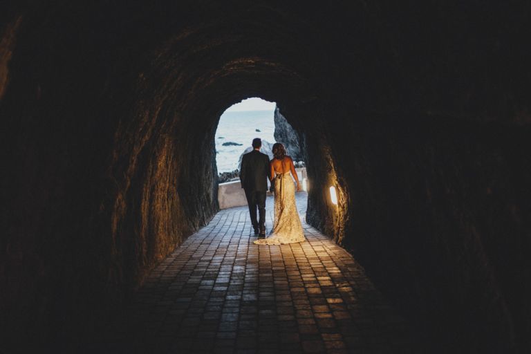 Bride and groom walking through the tunnel