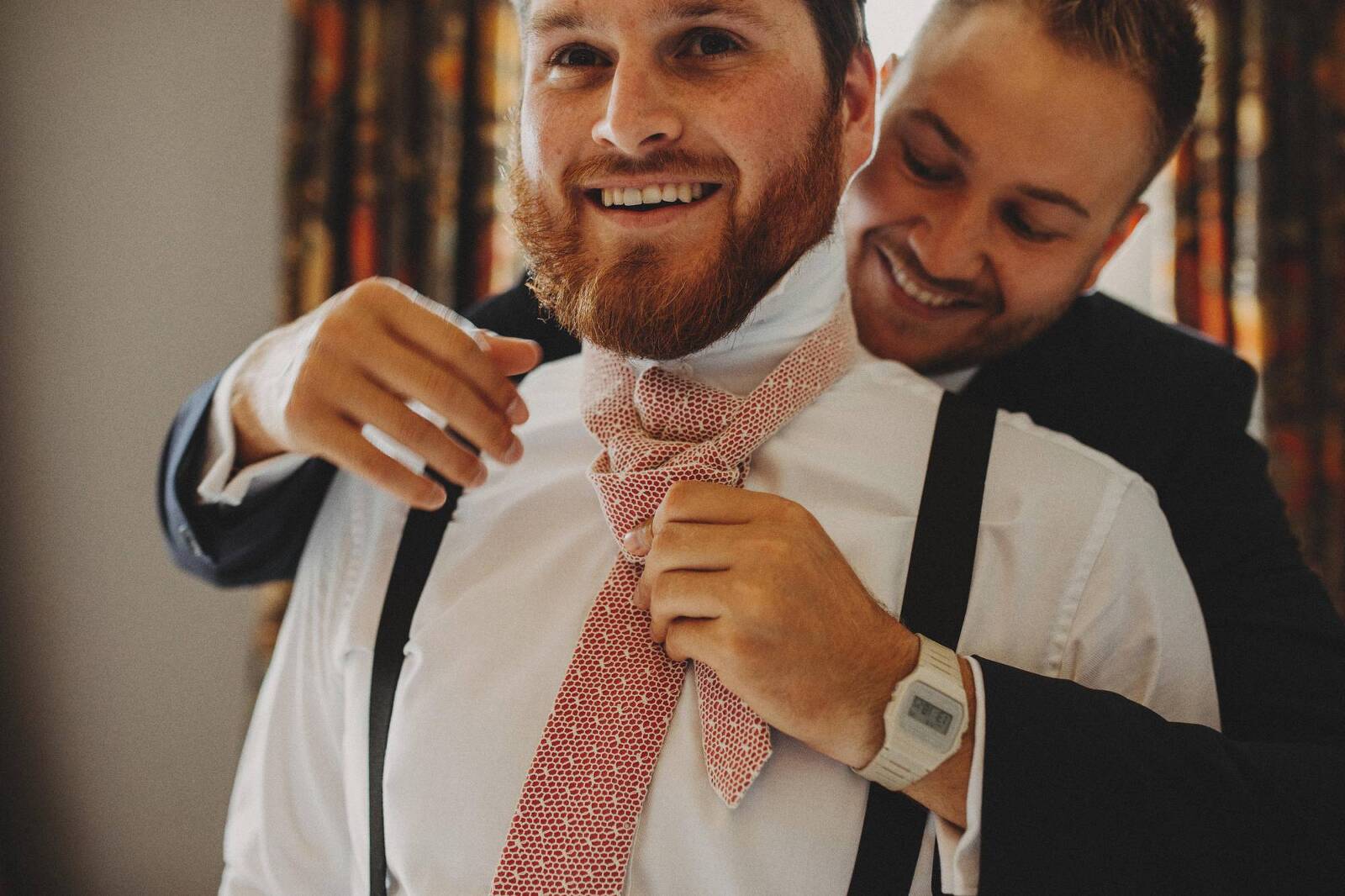 groomsmen putting on ties