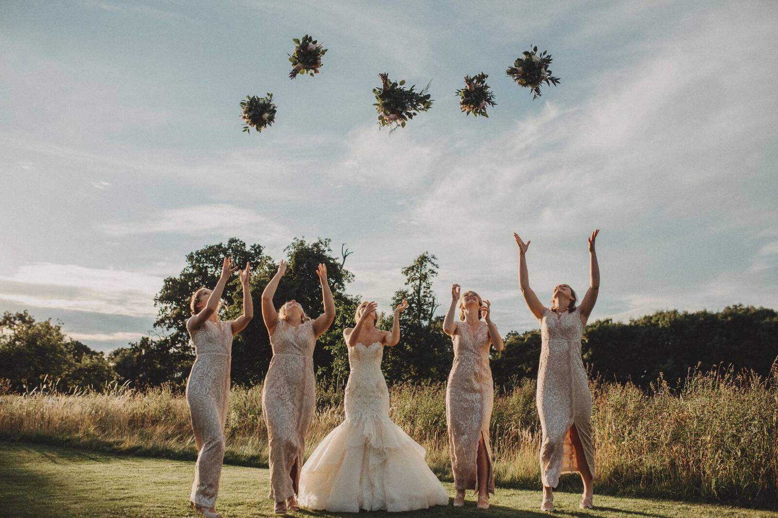 bridesmaids throwing flowers in the air